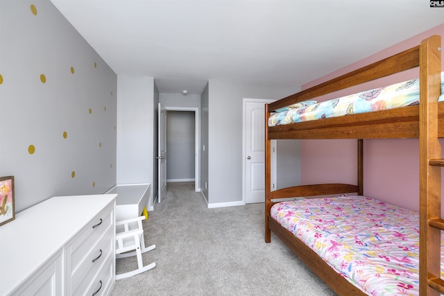 bedroom featuring baseboards, a closet, and light colored carpet