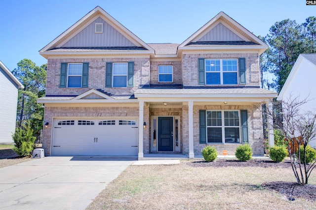 craftsman-style house featuring covered porch, brick siding, and driveway