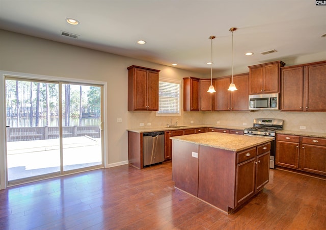 kitchen featuring dark wood-type flooring, visible vents, stainless steel appliances, and a sink