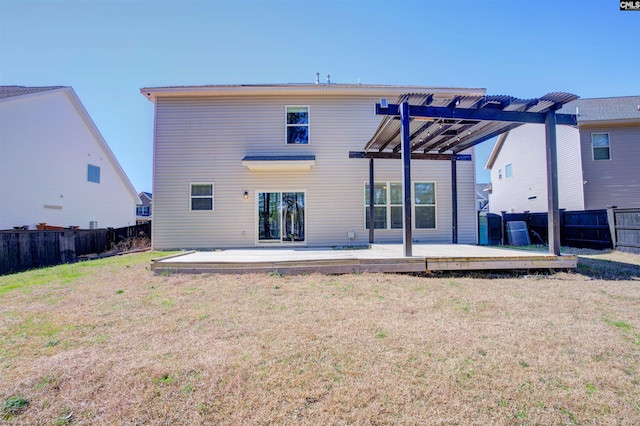 rear view of property featuring a fenced backyard, a deck, a pergola, and a yard