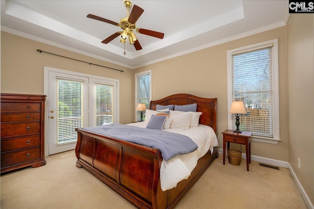 bedroom with light carpet, access to outside, a tray ceiling, and visible vents