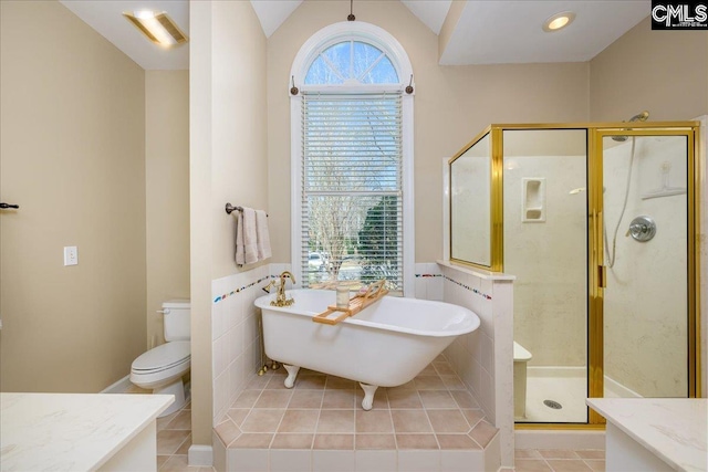 bathroom with toilet, a shower stall, vanity, tile patterned flooring, and a freestanding tub