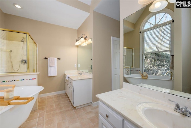 bathroom with two vanities, a sink, baseboards, a freestanding bath, and a stall shower