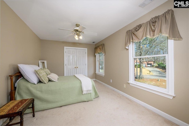 carpeted bedroom with baseboards, visible vents, ceiling fan, and a closet