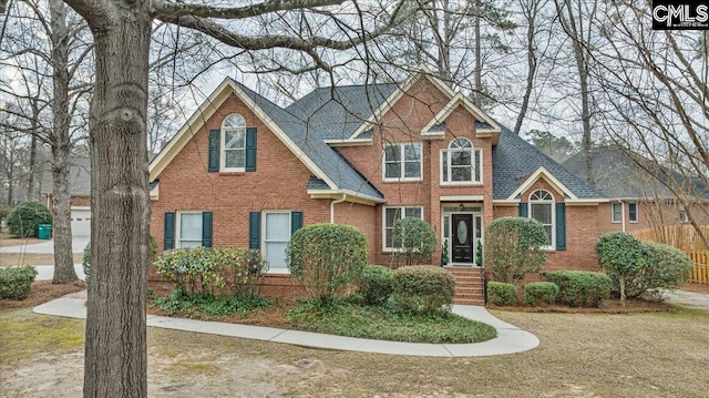 view of front of home featuring brick siding and a shingled roof