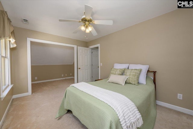 bedroom with light carpet, ceiling fan, visible vents, and baseboards