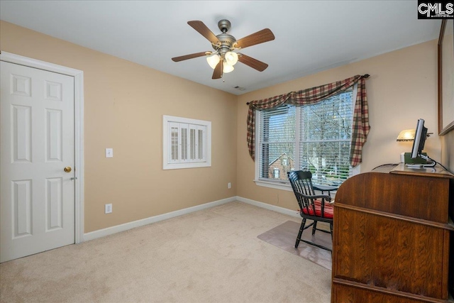 office area with light colored carpet, ceiling fan, and baseboards