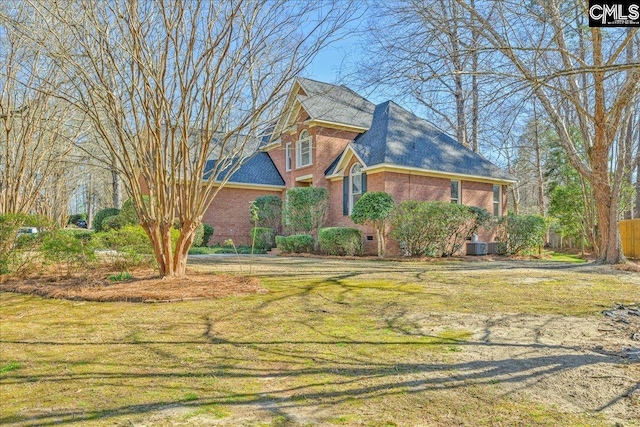 view of front of house with brick siding, crawl space, and a front yard