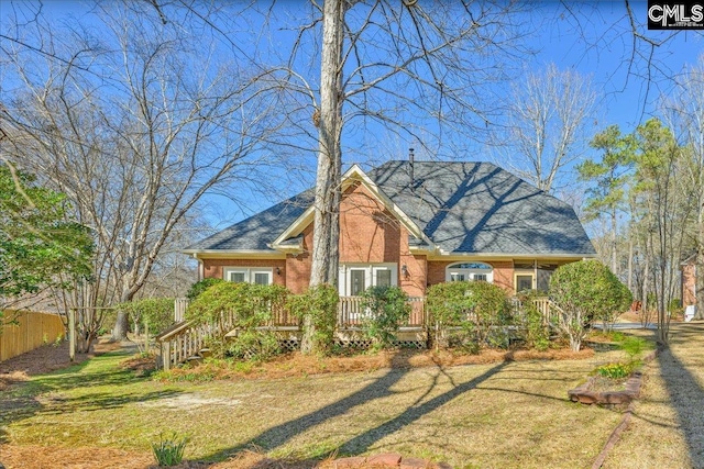 view of front of property featuring brick siding, a front yard, and fence