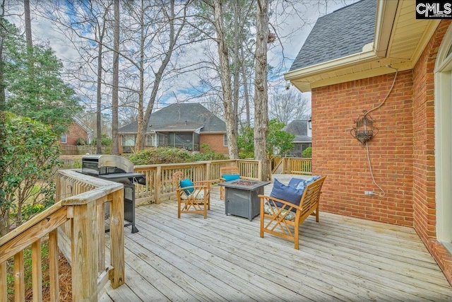 wooden terrace featuring a fire pit and grilling area