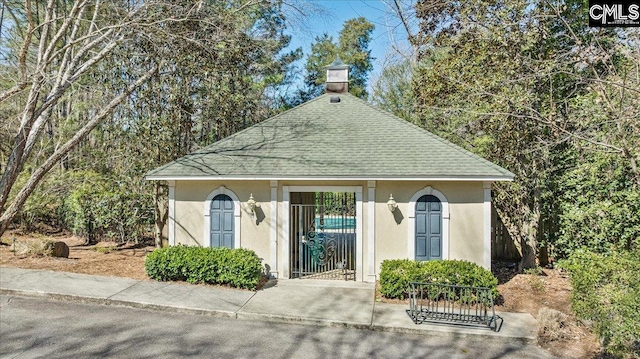 view of front of house with a shingled roof and stucco siding