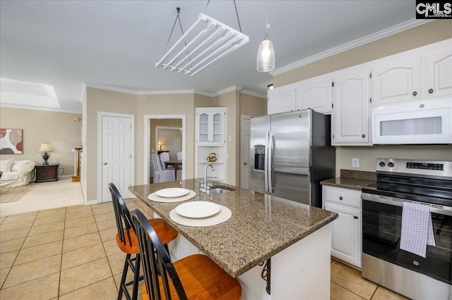 kitchen with light tile patterned floors, dark stone counters, appliances with stainless steel finishes, crown molding, and a sink