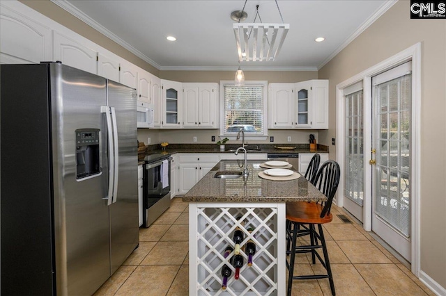 kitchen with a breakfast bar, crown molding, appliances with stainless steel finishes, glass insert cabinets, and white cabinets