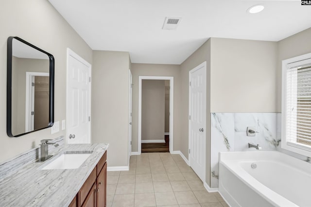 full bathroom with visible vents, baseboards, a garden tub, tile patterned flooring, and vanity