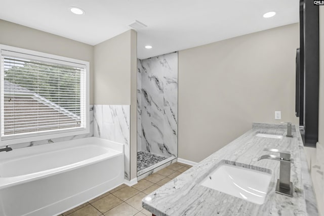 full bathroom featuring a garden tub, a sink, a marble finish shower, tile patterned floors, and double vanity