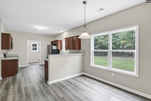 kitchen with baseboards, visible vents, stainless steel appliances, light countertops, and light wood-style floors