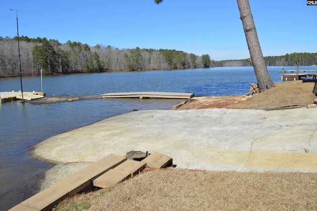 view of dock featuring a water view and a forest view