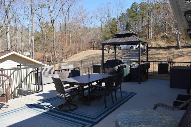 wooden terrace with a gazebo and outdoor dining area