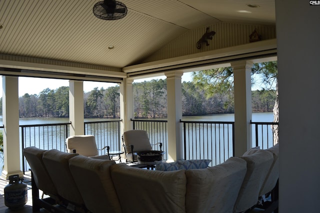 sunroom with lofted ceiling and a water view