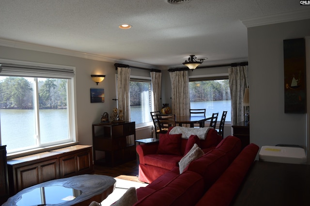 living room with ornamental molding, a water view, wood finished floors, and a healthy amount of sunlight