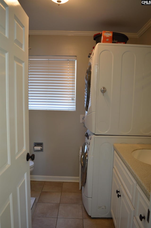 washroom featuring ornamental molding, stacked washer / dryer, and light tile patterned floors