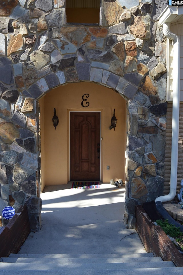 doorway to property featuring stucco siding