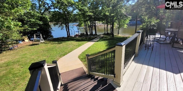 wooden terrace featuring a water view and a yard