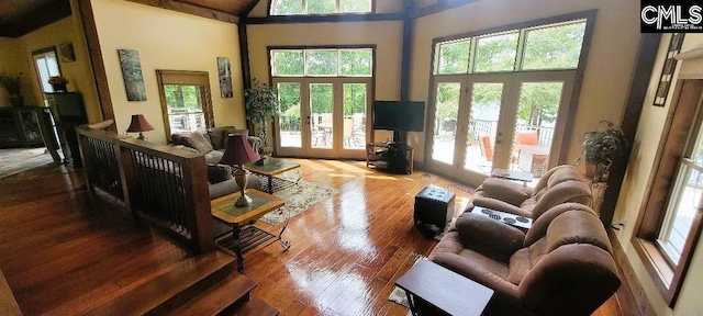 living area featuring a wealth of natural light, french doors, and a towering ceiling