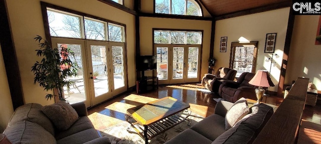 living room with a towering ceiling, wood finished floors, and french doors