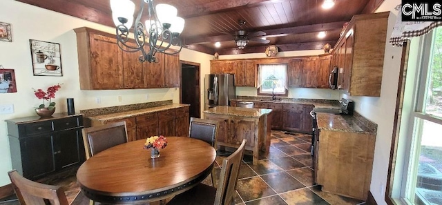 kitchen with wooden ceiling, stainless steel appliances, dark tile patterned flooring, a sink, and beamed ceiling