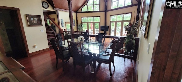 dining room with vaulted ceiling, stairway, wood finished floors, and baseboards