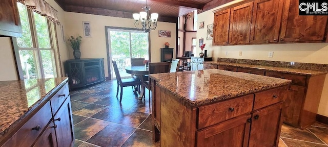 kitchen with dark stone counters, wood ceiling, beamed ceiling, a center island, and a notable chandelier