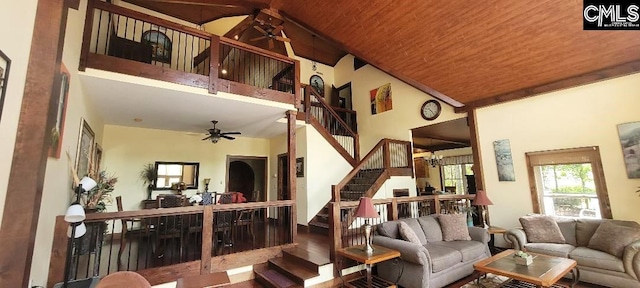 living room with a towering ceiling, wood ceiling, stairway, and a ceiling fan