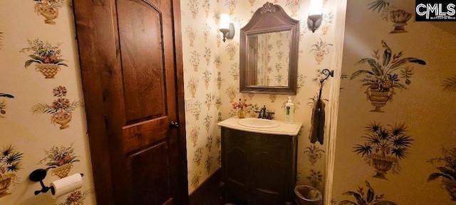 bathroom with vanity and wallpapered walls