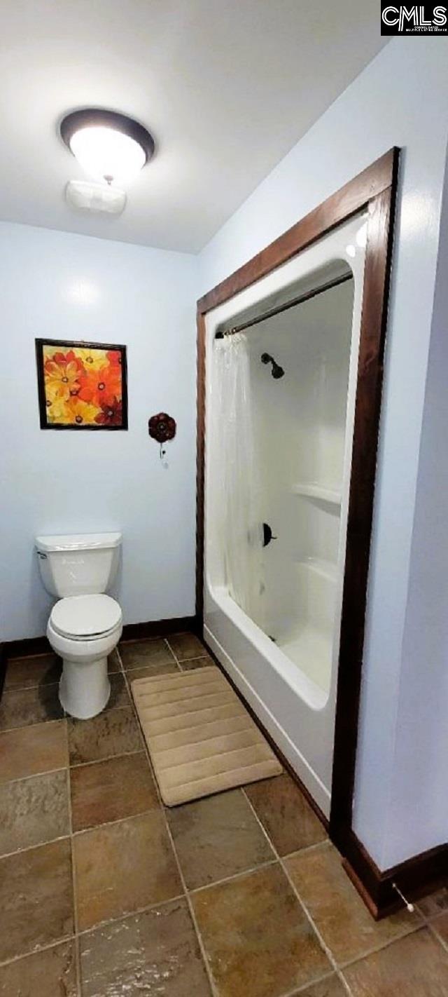 bathroom featuring toilet and baseboards