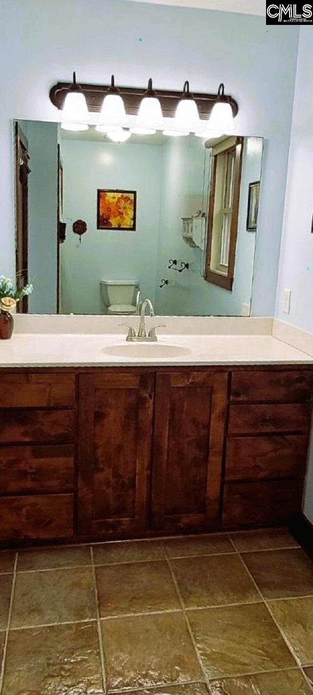 bathroom featuring toilet and vanity