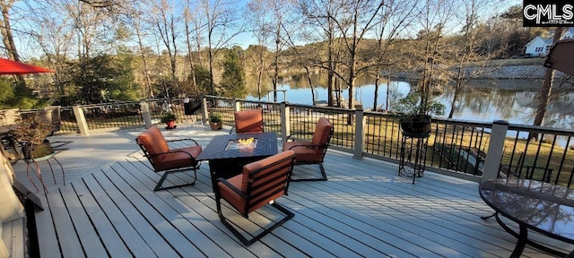 deck with an outdoor fire pit and a water view