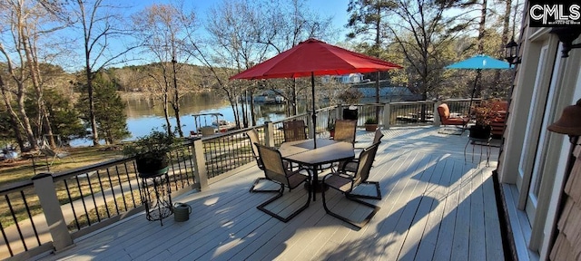 deck featuring outdoor dining area and a water view