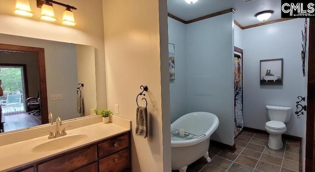 bathroom with baseboards, toilet, ornamental molding, tile patterned floors, and a freestanding tub