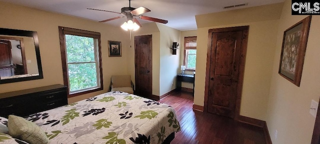 bedroom featuring dark wood-style floors, multiple windows, visible vents, and baseboards