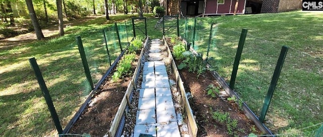 view of yard featuring fence and a garden