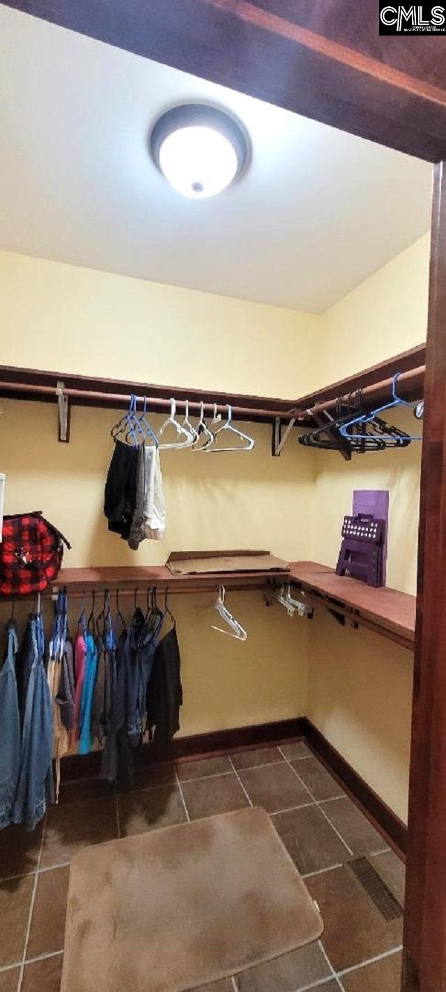 spacious closet featuring dark tile patterned floors