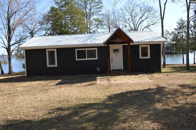 view of front of house with board and batten siding, a water view, and metal roof