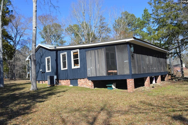 view of side of property featuring crawl space, a sunroom, central AC unit, and a yard