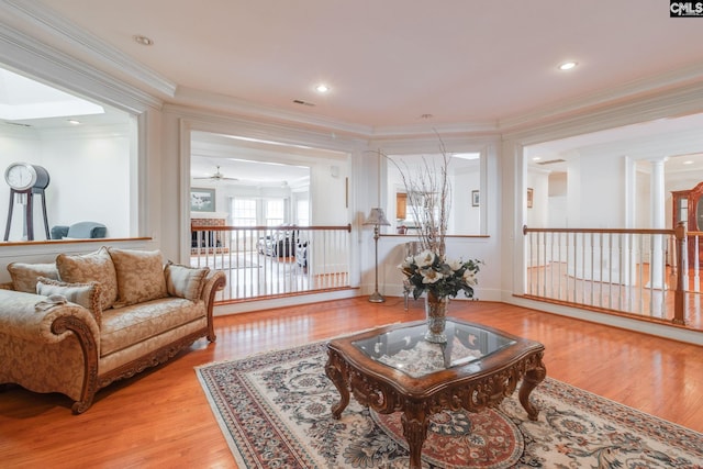 sitting room with crown molding, visible vents, and wood finished floors