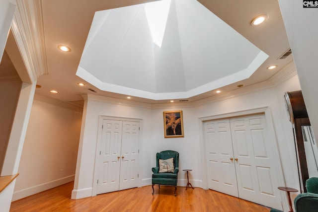 unfurnished room featuring baseboards, ornamental molding, a tray ceiling, light wood-type flooring, and recessed lighting