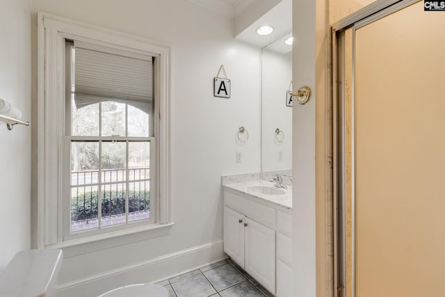 bathroom with plenty of natural light, vanity, baseboards, and tile patterned floors