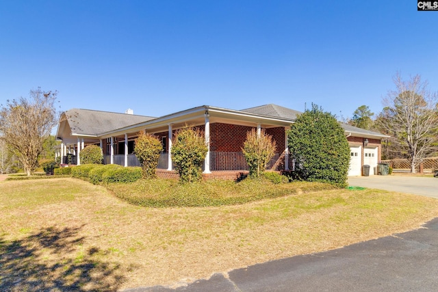 single story home featuring a garage, concrete driveway, brick siding, and a front lawn