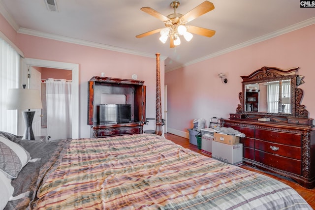 bedroom with baseboards, visible vents, ornamental molding, and wood finished floors