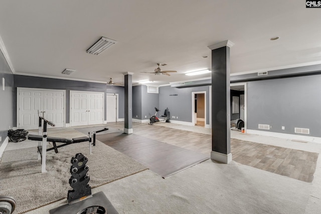 exercise room featuring a ceiling fan, visible vents, ornamental molding, and wood finished floors